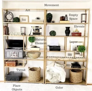 Two tall, gold open shelving units are styled with various decorative objects, including books, plants, a vintage record player, and baskets. Text labels overlay the shelves indicating design principles like 'Art', 'Movement', 'Natural Element', 'Empty Space', 'Elevate', 'Layer', 'Tweak', 'Place Objects', and 'Color'.
