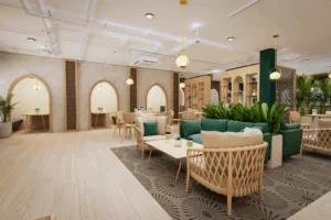 A modern cafe interior featuring comfortable green sofas, woven armchairs, light wood tables, and arched seating nooks, decorated with plants and warm lighting.