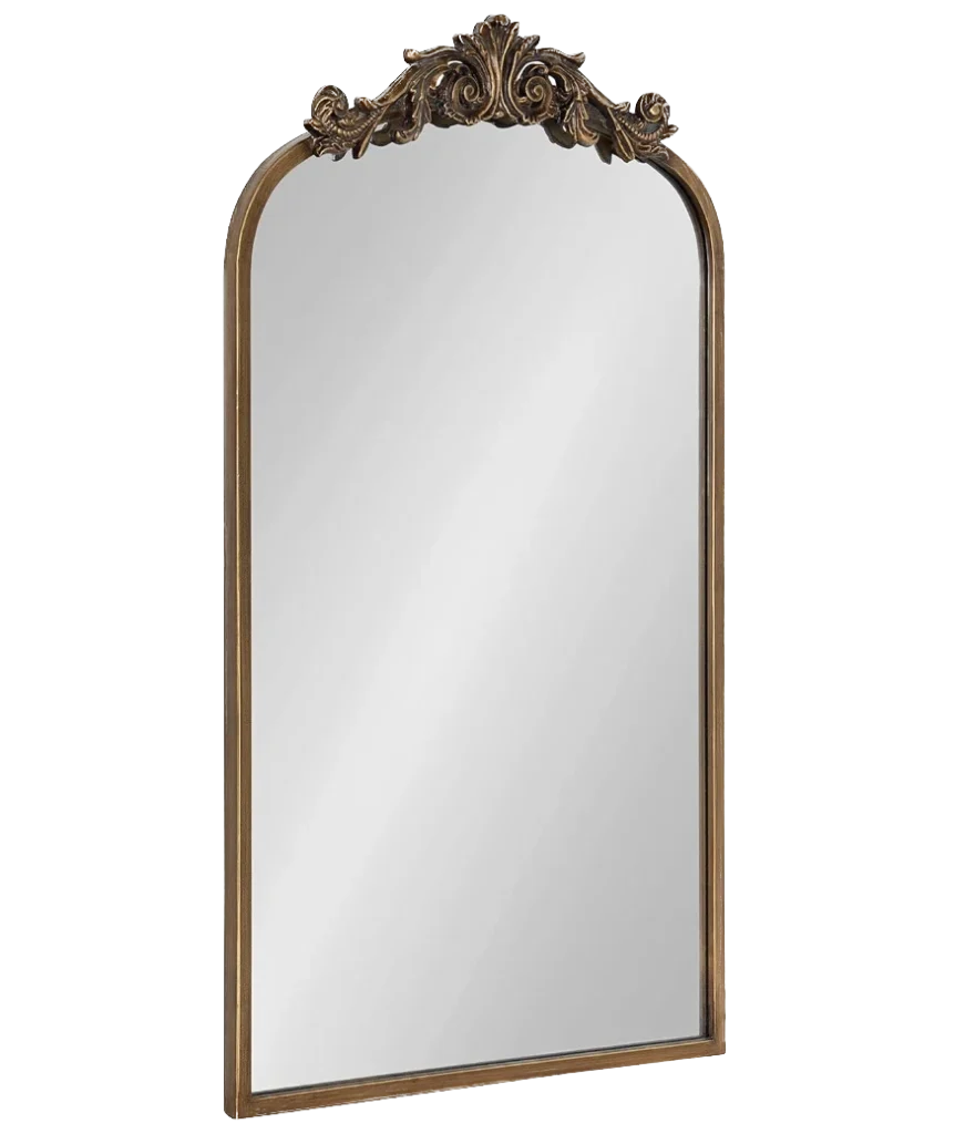 A decorative arch-top mirror with an ornate gold frame and detailed scrollwork at the apex.